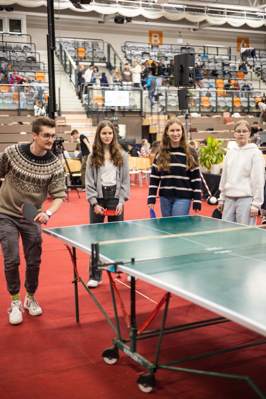 Jugendliche spielen Tischtennis in der Halle